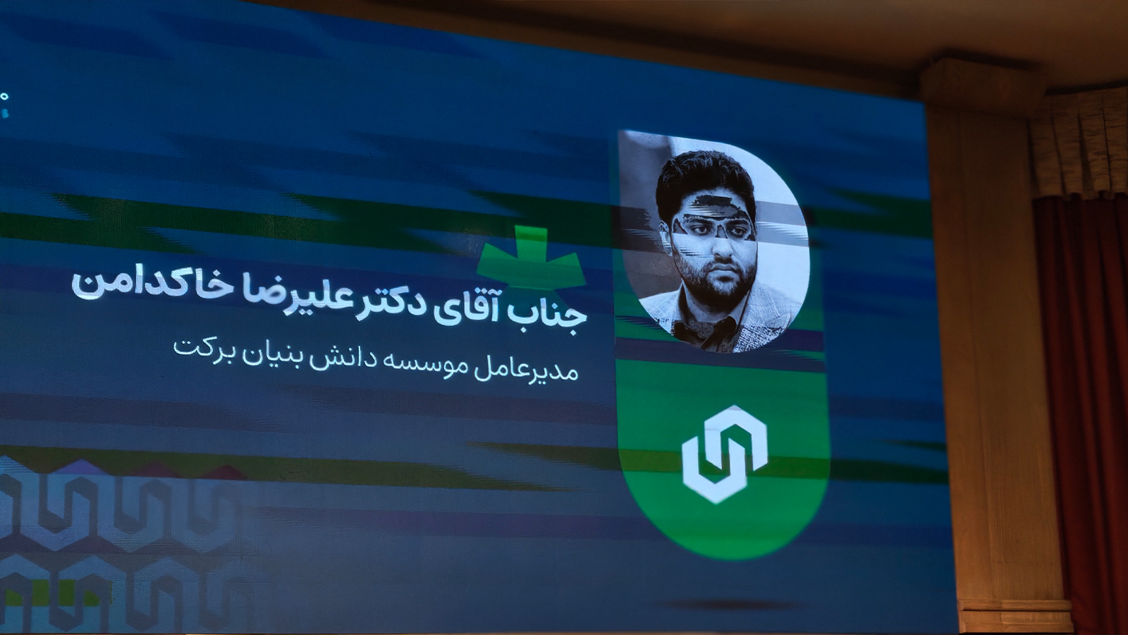 تصویر نزدیک از تندیس و نشان رویداد ۱۰۰ استارتآپ در کنار فضای برگزاری رویداد