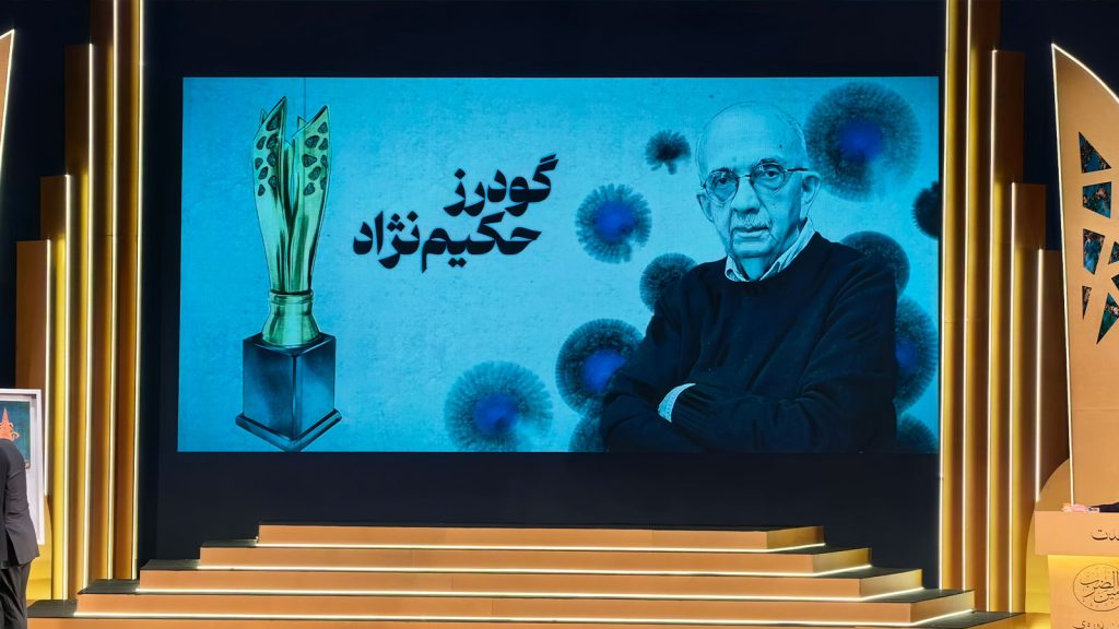 نماینده گودرز حکیمی‌نژاد، بنیان‌گذار آبسال، هنگام دریافت جایزه دهمین جشنواره امین‌الضرب